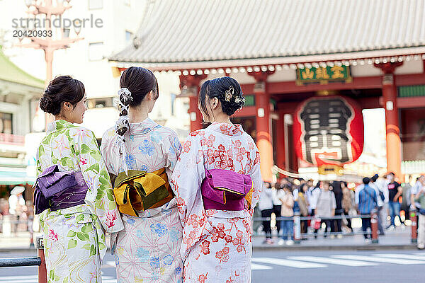 Japanese friends wearing yukata visiting traditional temple in Tokyo