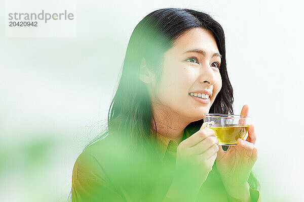 Japanese woman drinking tea against white background