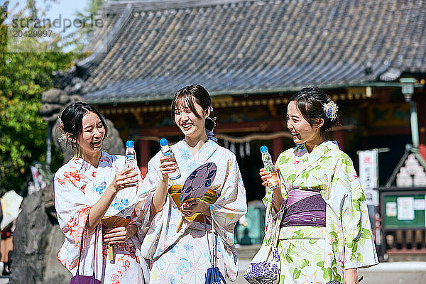 Japanese friends wearing yukata visiting traditional temple in Tokyo