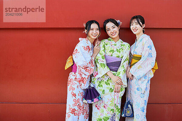 Japanese friends wearing yukata visiting traditional temple in Tokyo