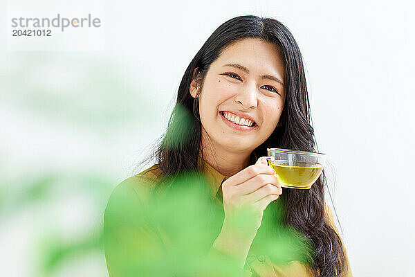 Japanese woman drinking tea against white background