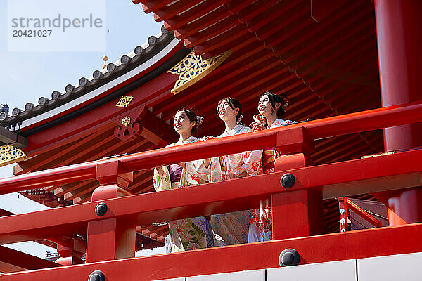 Japanese friends wearing yukata visiting traditional temple in Tokyo