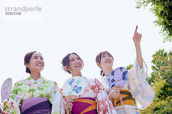 Japanese friends wearing yukata visiting traditional temple in Tokyo