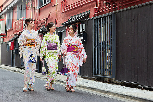 Japanese friends wearing yukata visiting traditional area in Tokyo