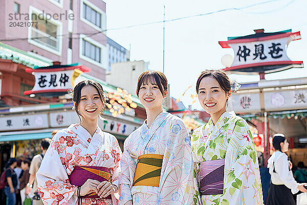 Japanese friends wearing yukata visiting traditional temple in Tokyo