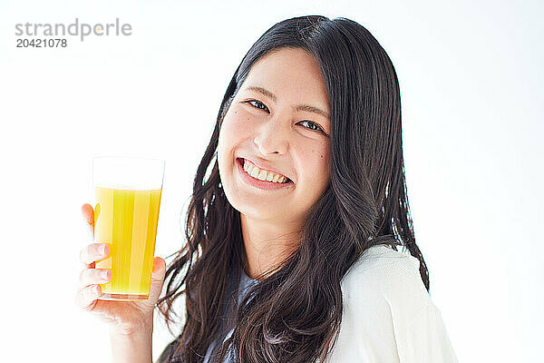 Japanese woman holding a glass of orange juice