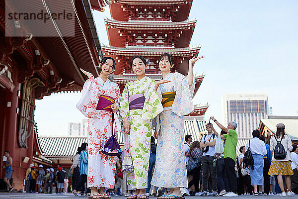 Japanese friends wearing yukata visiting traditional temple in Tokyo