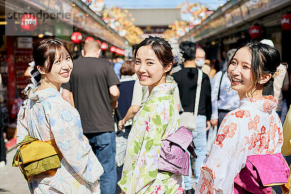 Japanese friends wearing yukata visiting traditional temple in Tokyo