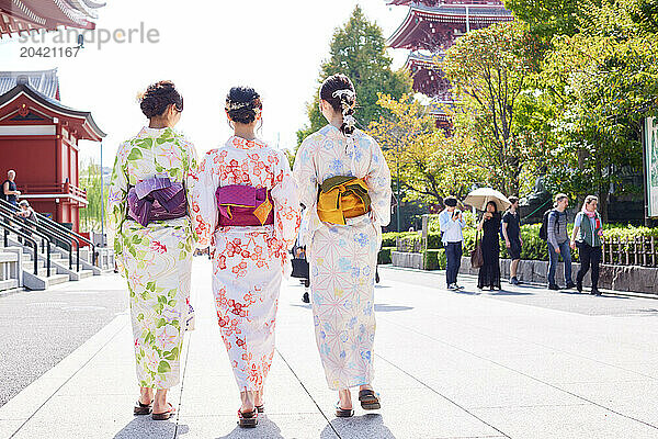 Japanese friends wearing yukata visiting traditional temple in Tokyo