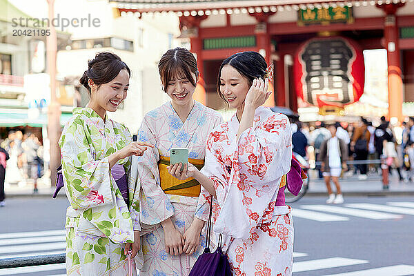 Japanese friends wearing yukata visiting traditional temple in Tokyo