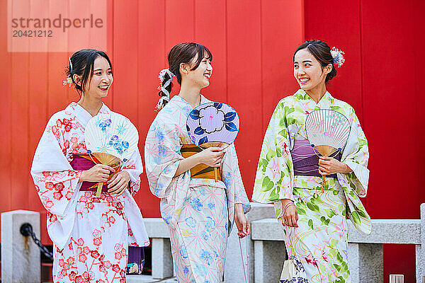 Japanese friends wearing yukata visiting traditional temple in Tokyo