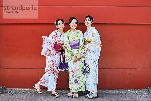 Japanese friends wearing yukata visiting traditional temple in Tokyo