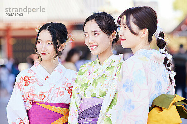 Japanese friends wearing yukata visiting traditional temple in Tokyo