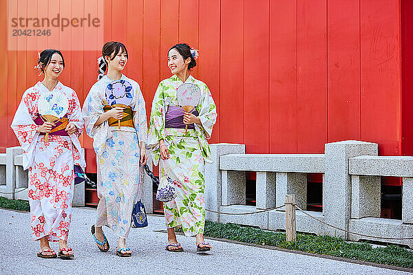 Japanese friends wearing yukata visiting traditional temple in Tokyo