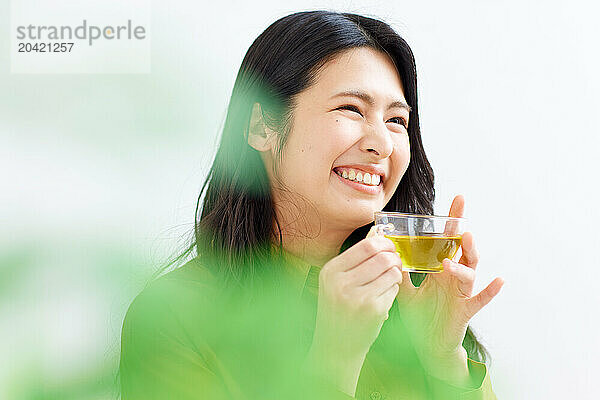 Japanese woman drinking tea against white background