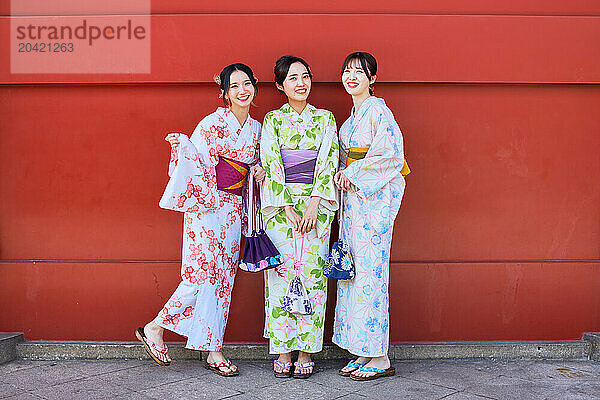 Japanese friends wearing yukata visiting traditional temple in Tokyo