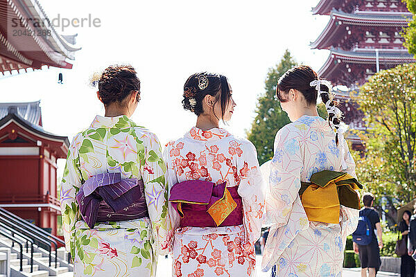 Japanese friends wearing yukata visiting traditional temple in Tokyo