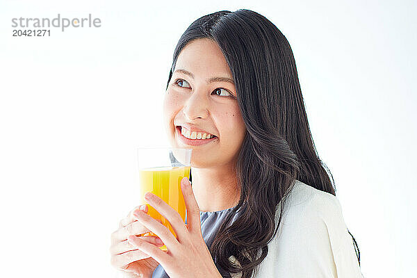 Japanese woman holding a glass of orange juice