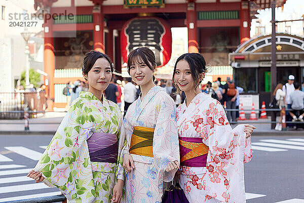 Japanese friends wearing yukata visiting traditional temple in Tokyo