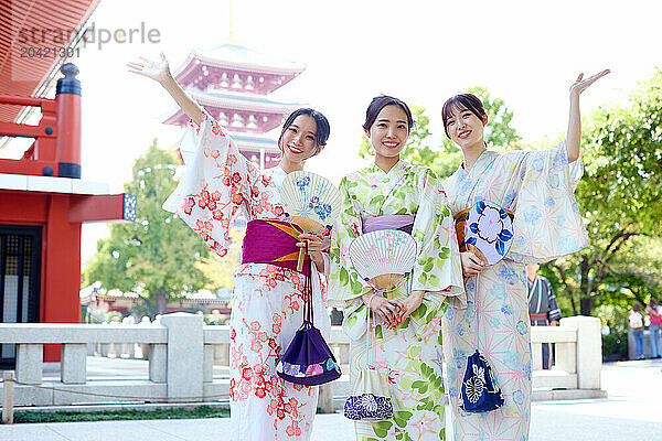 Japanese friends wearing yukata visiting traditional temple in Tokyo