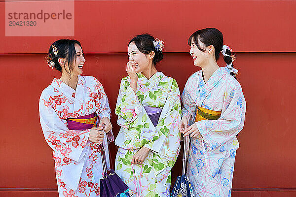 Japanese friends wearing yukata visiting traditional temple in Tokyo