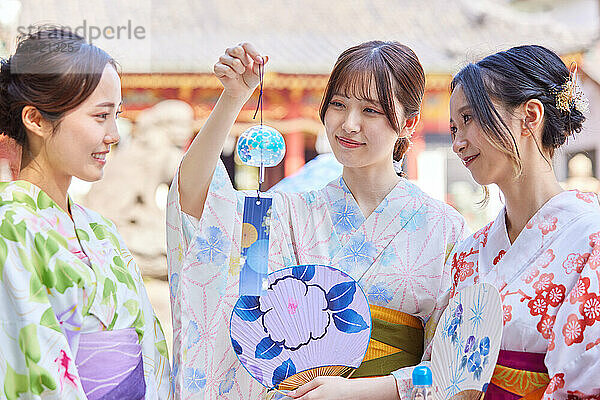 Japanese friends wearing yukata visiting traditional temple in Tokyo