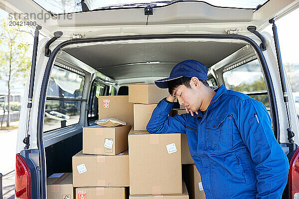 Japanese delivery man checking boxes in the car