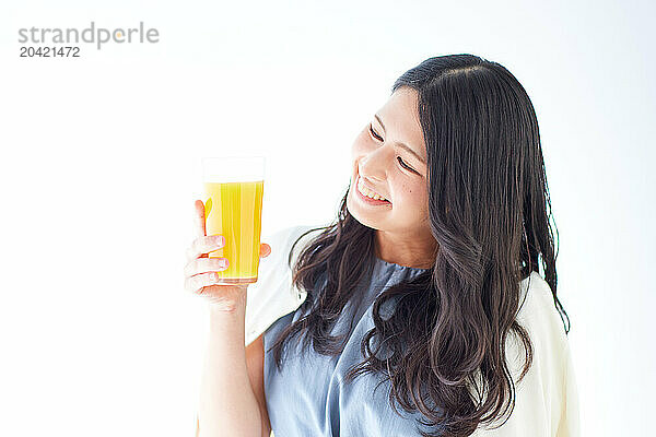 Japanese woman holding a glass of orange juice