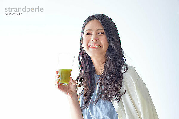 Japanese woman holding a glass of green juice