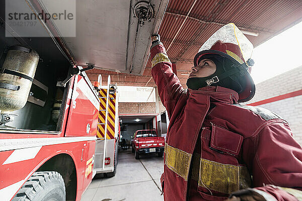 Female firefighter working at fire engine