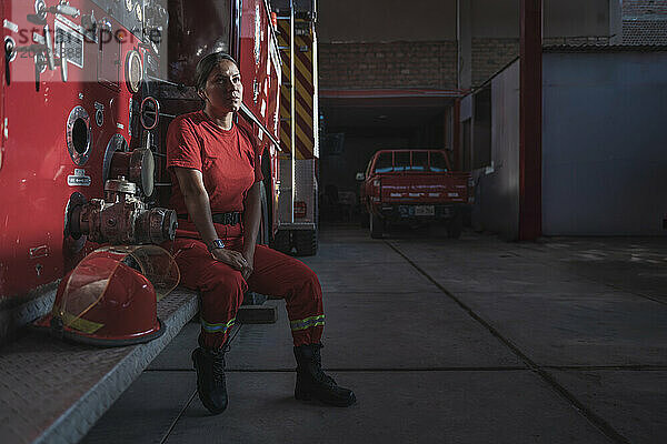 Portrait of female firefighter standing at fire station