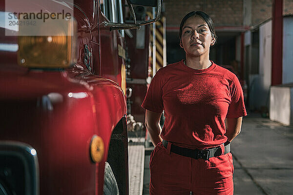 Portrait of smiling female firefighter standing at fire station