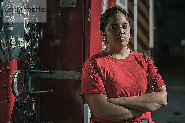 Portrait of female firefighter standing at fire station