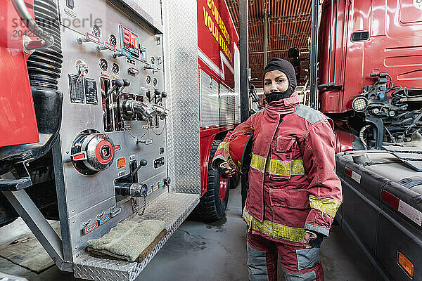 Female Firefighter In Fire Protection Suit standing at fire station