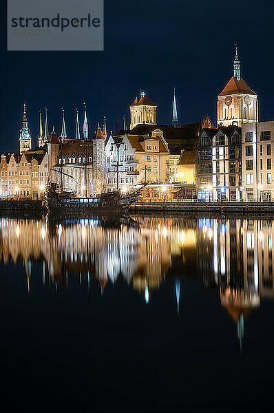 Gdansk's Historic Towers Mirrored in Tranquil Waters at Night