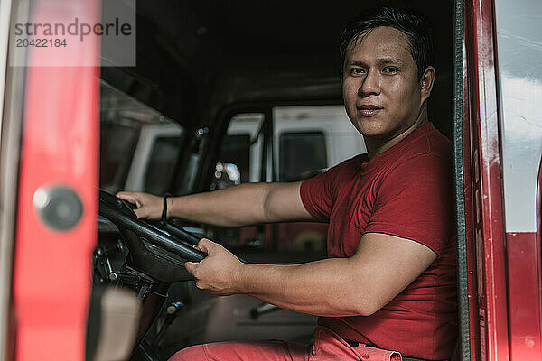 Portrait of fire truck driver smiling at fire station