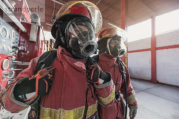 Female firefighter with workwear working at fire station