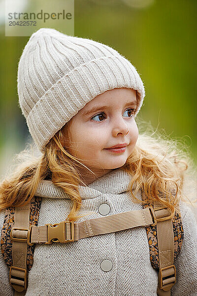 Portrait of a happy girl with curly hair in a hat