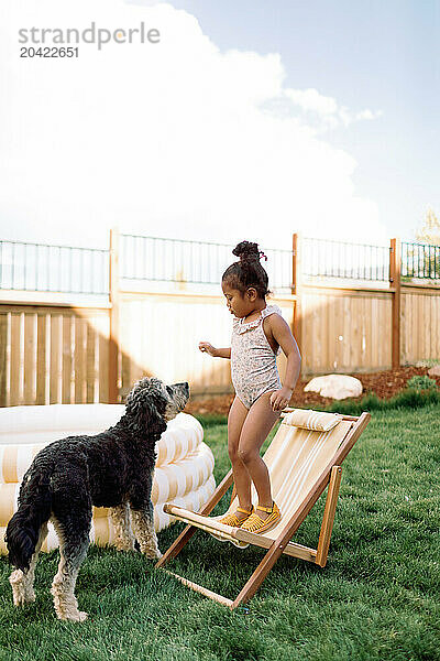 Toddler Girl and Golden-doodle Puppy Backyard Summer