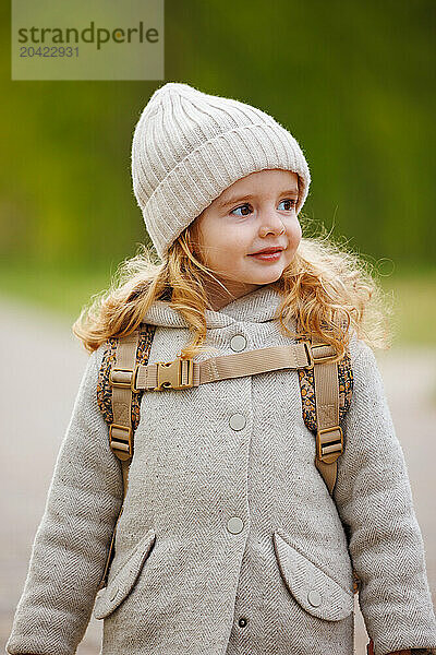 Portrait of a happy girl with curly hair in a hat