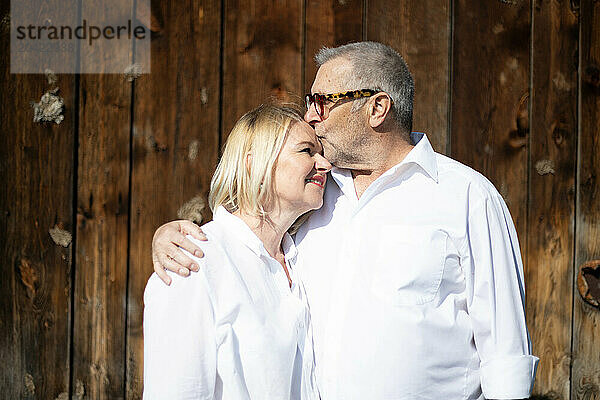 Senior couple in white sharing a loving embrace