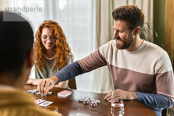 enjoying friends sitting at table and play card games