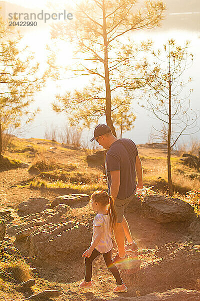 Father and daughter hiking by lake