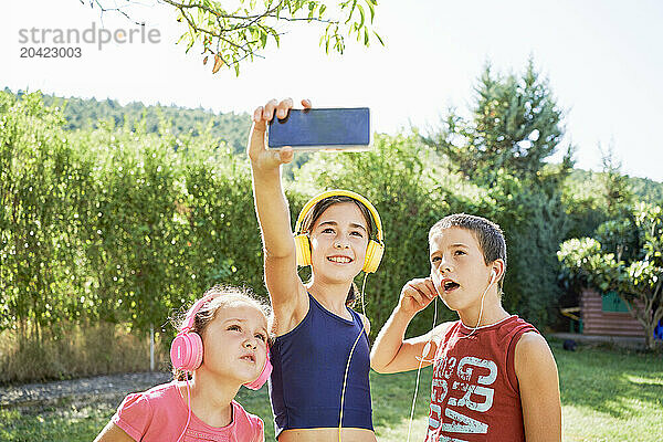 portrait of three boys in sportswear standing taking a selfie