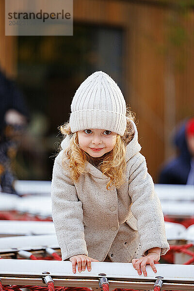 Portrait of a small smiling girl on a playground in a city park