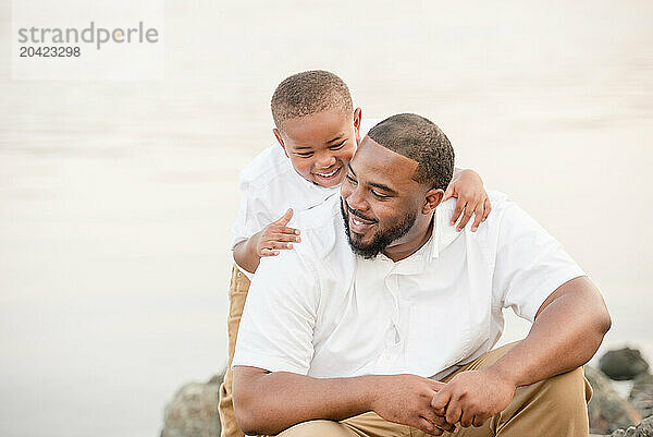 Son on dads back laughing outdoors