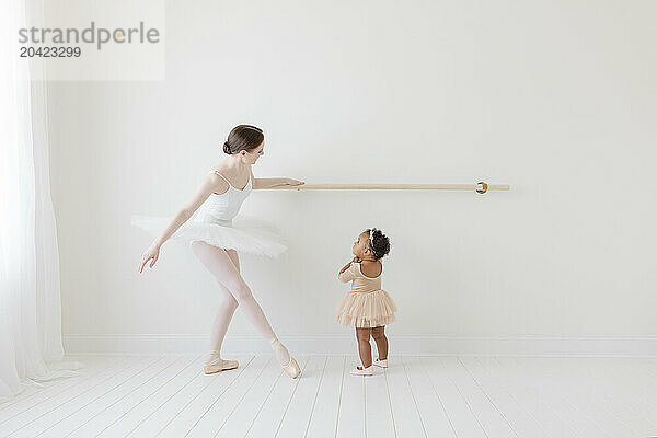 ballerina shows mixed race baby in tutu how to dance