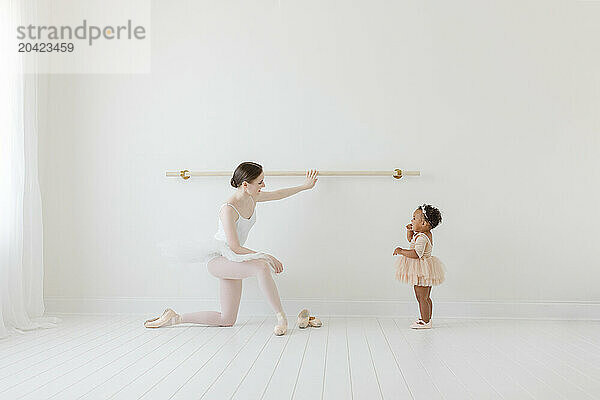 One year old ballerina admires ballet instructor