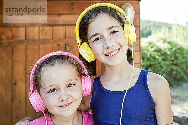 portrait of two smiling sisters standing in sportswear