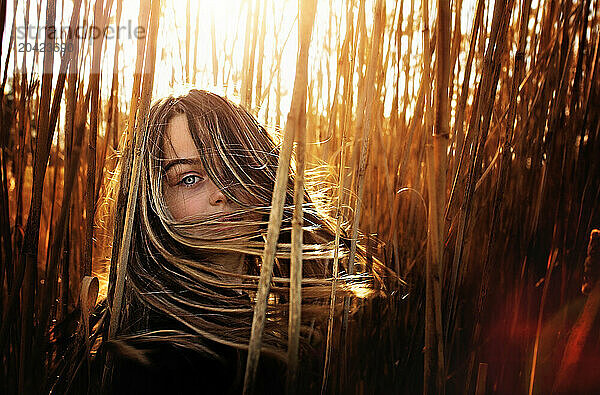 Beautiful young girl looking into camera with blue eyes hair blowing